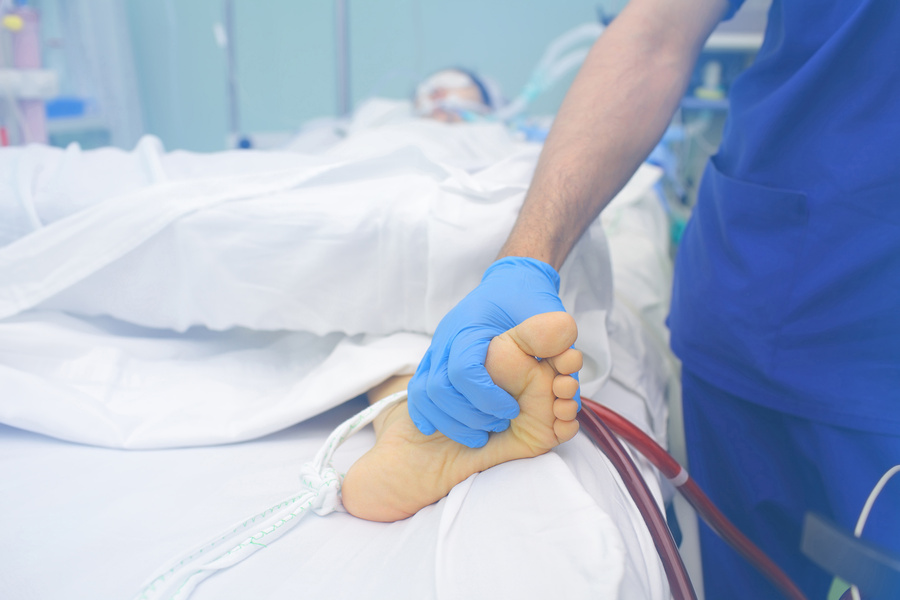 Doctor Palpating Patient's Feet in the Critical Care